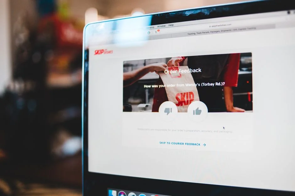 Dual monitors on a desk, showcasing web design in a modern office setting.